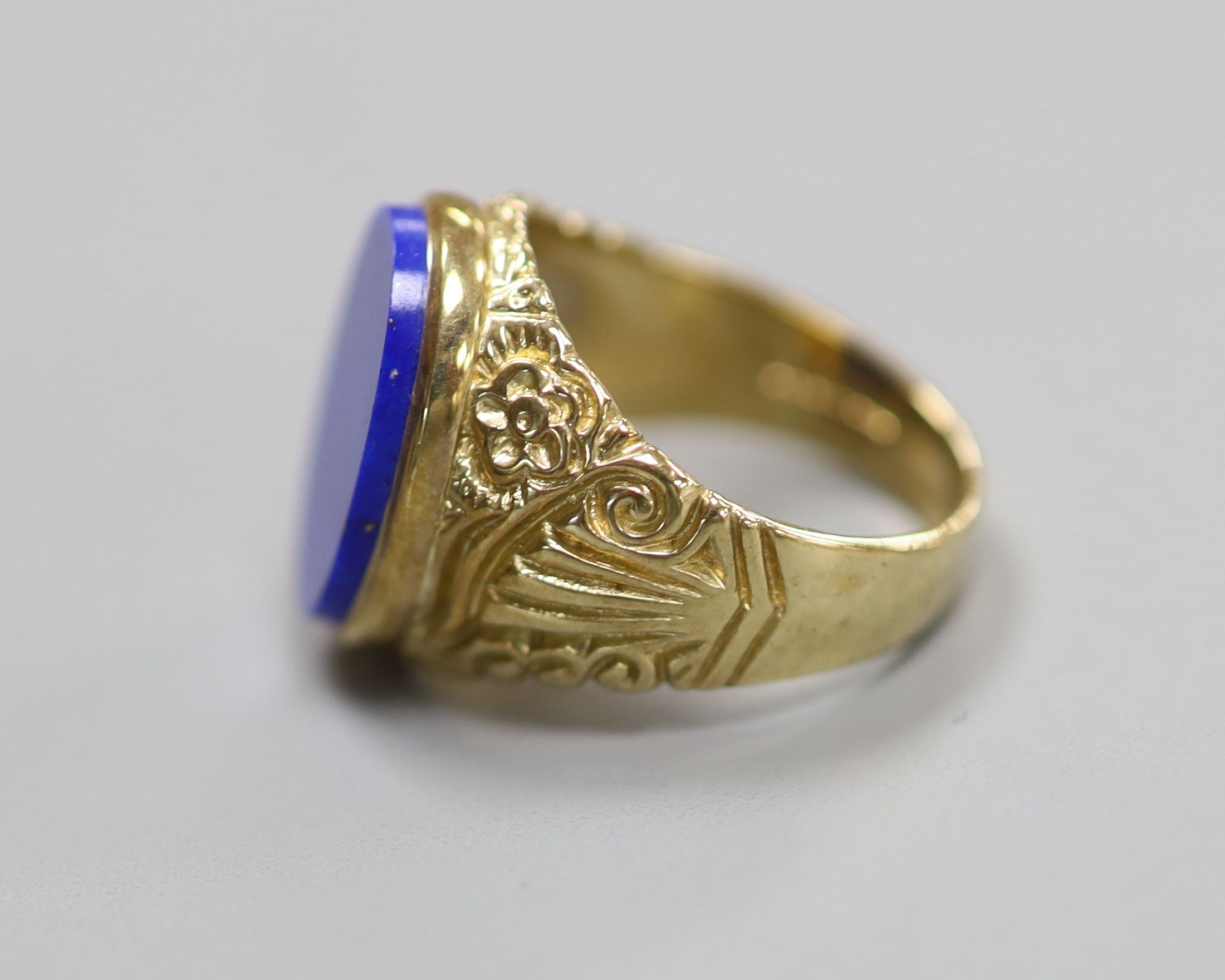 A modern 9ct gold and lapis lazuli set oval signet ring, with carved shoulders, size O